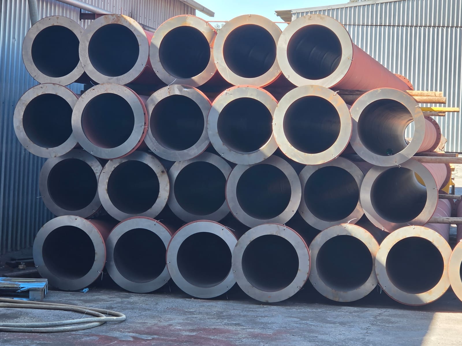 Stacked large-diameter steel pipes ready for fabrication at the Wetpipe workshop